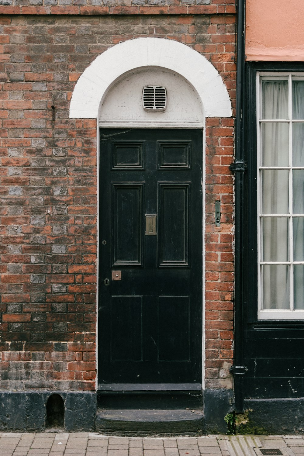 black wooden door on brown brick wall