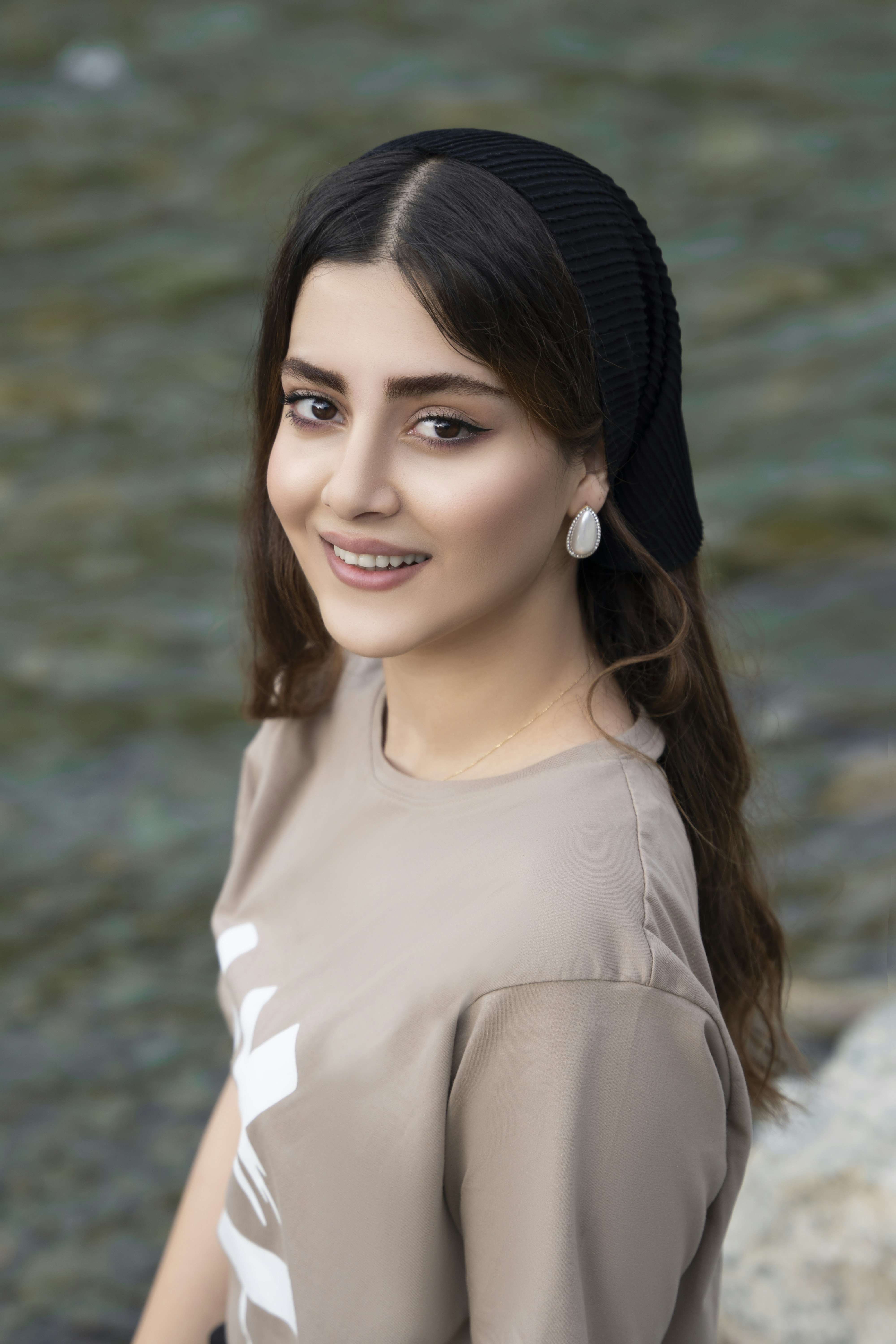 woman in white crew neck shirt and black knit cap smiling