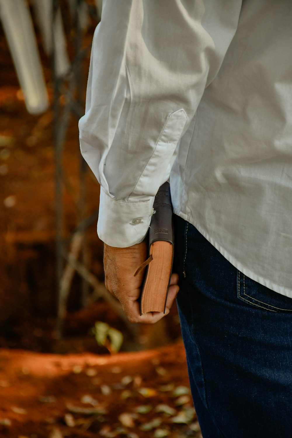 person in white dress shirt and blue denim jeans