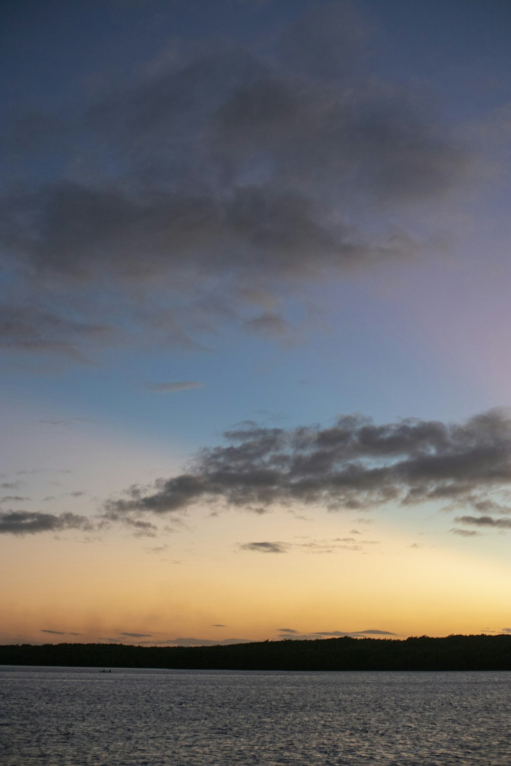 a large body of water under a cloudy sky