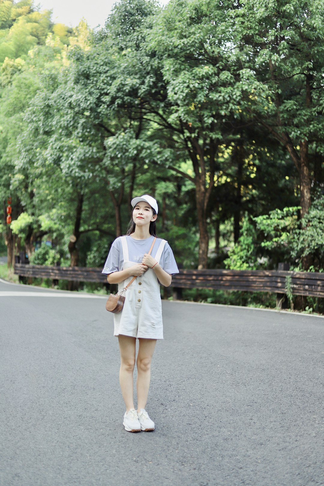 woman in white dress standing on gray asphalt road during daytime