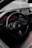 A sleek car interior featuring a BMW steering wheel with a sporty, high-tech design. The dashboard is sophisticated with illuminated red dials and a digital screen.