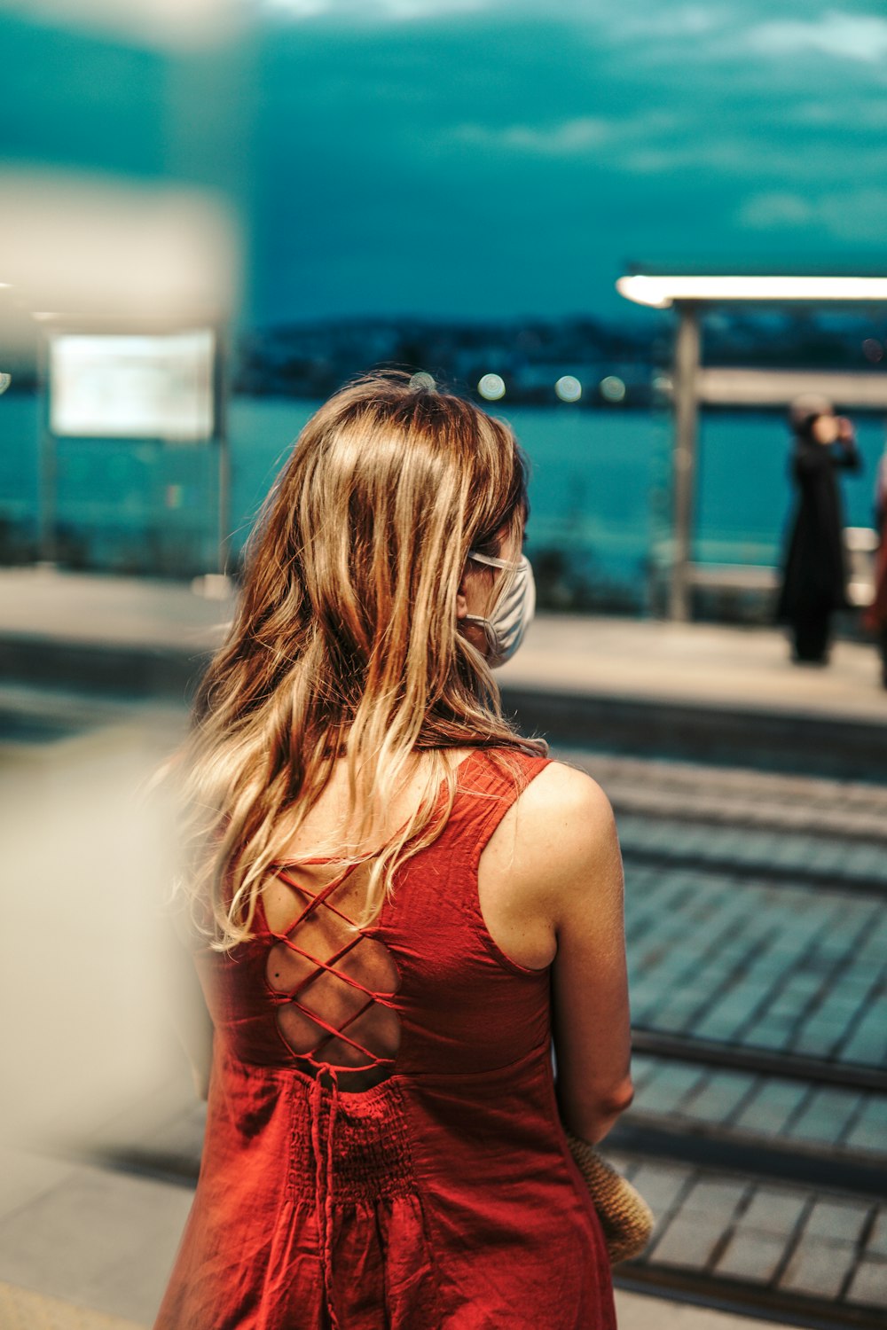 a woman in a red dress wearing a face mask