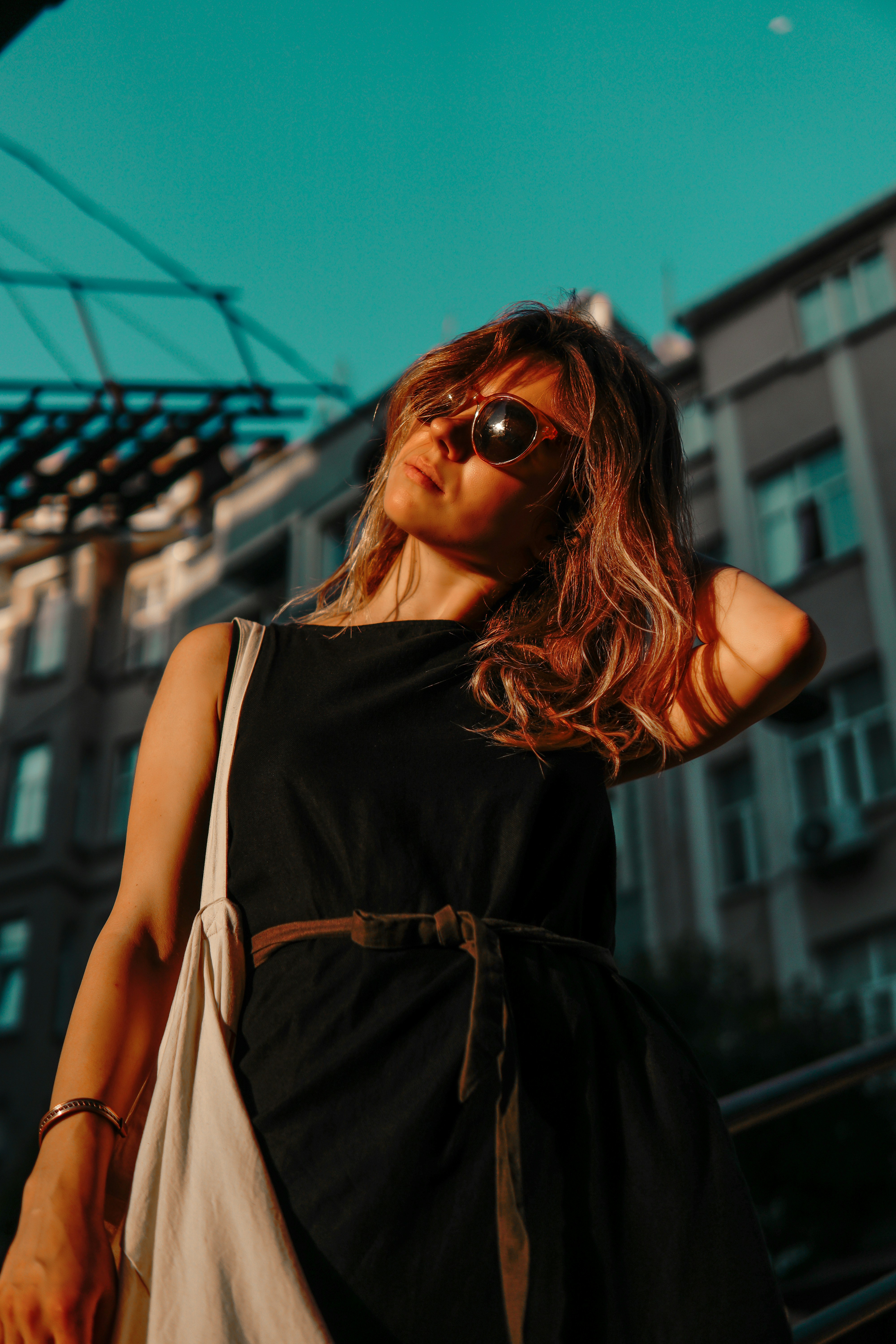 A woman wearing sunglasses standing in front of a building photo – Free ...