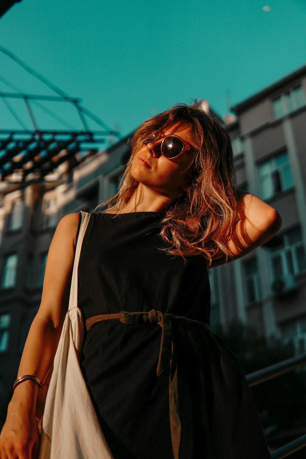 a woman wearing sunglasses standing in front of a building