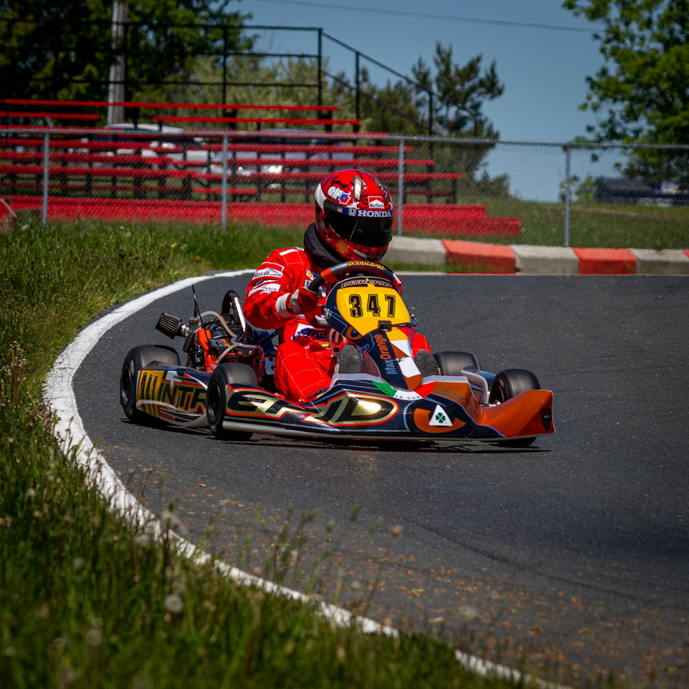 person riding on red and black go kart
