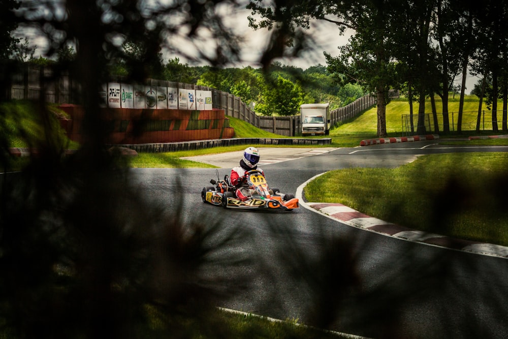 people riding go kart on road during daytime