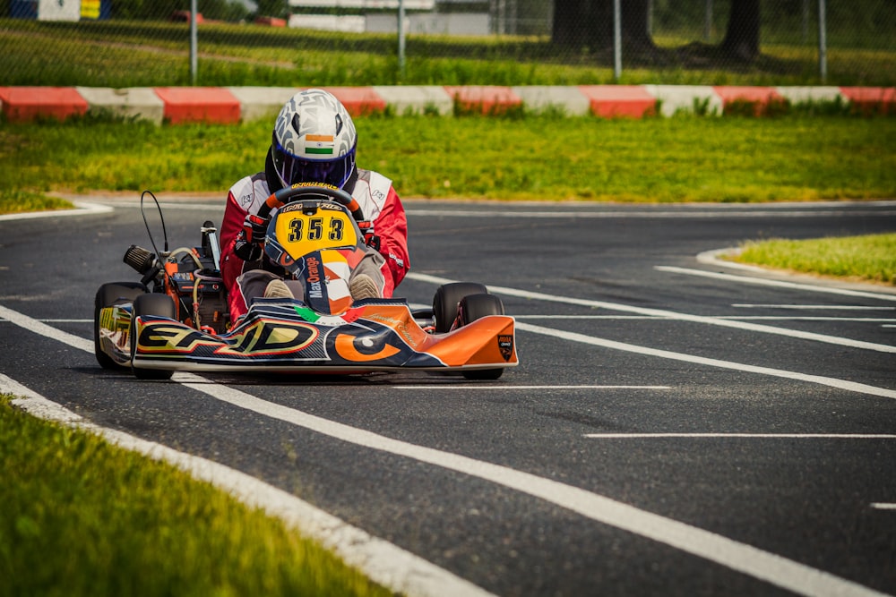 orange and blue go kart on track during daytime