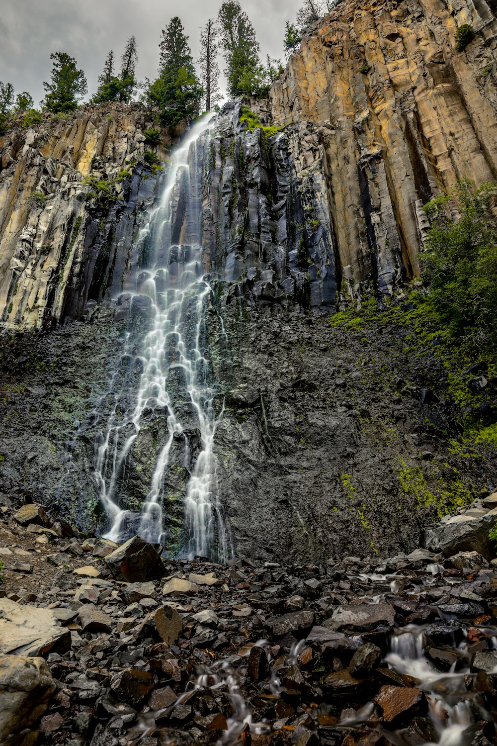 water falls in the middle of brown rocks