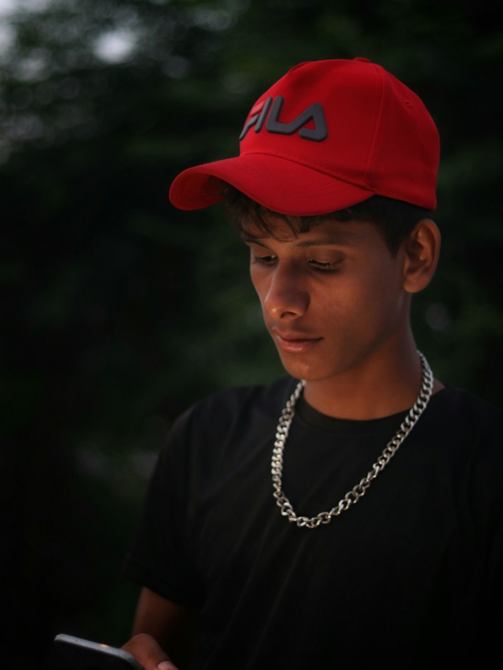 Hombre con camisa negra de cuello redondo con gorra roja