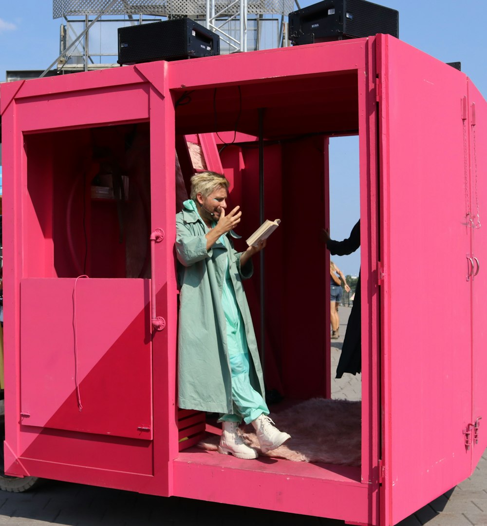 woman in blue robe standing in front of red wooden door