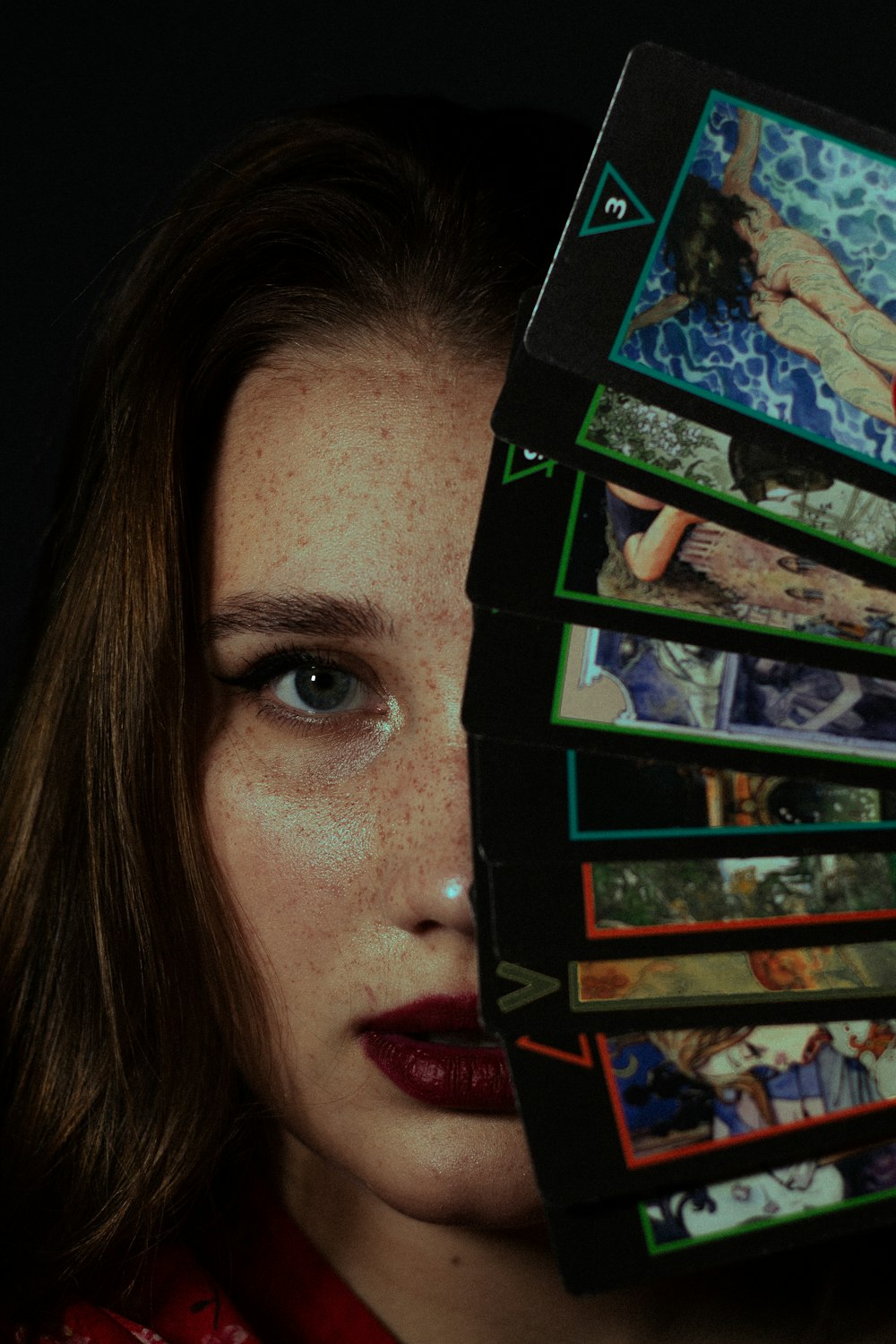 a woman holding up a stack of photos