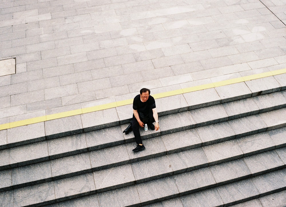 Foto Um homem sentado em uma escada – Imagem de Cinza grátis no Unsplash