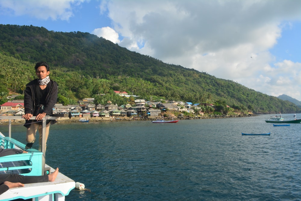 white and brown houses near body of water and mountain under blue sky during daytime