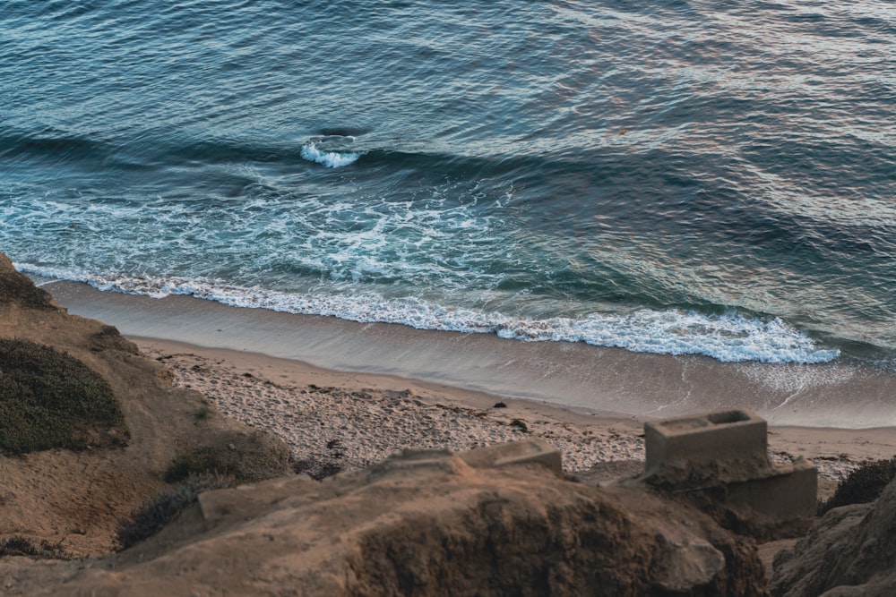 body of water near brown sand during daytime