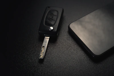 Close-up of a smartphone and a car key placed side by side, symbolizing diverse product categories.