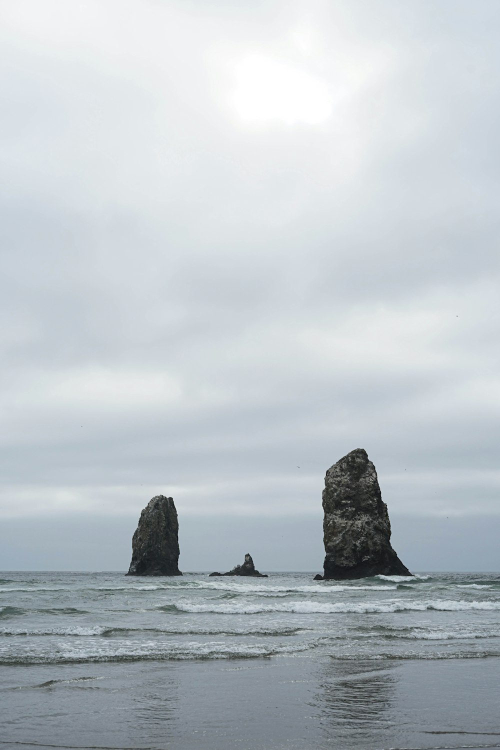 brown rock formation on sea under white clouds during daytime