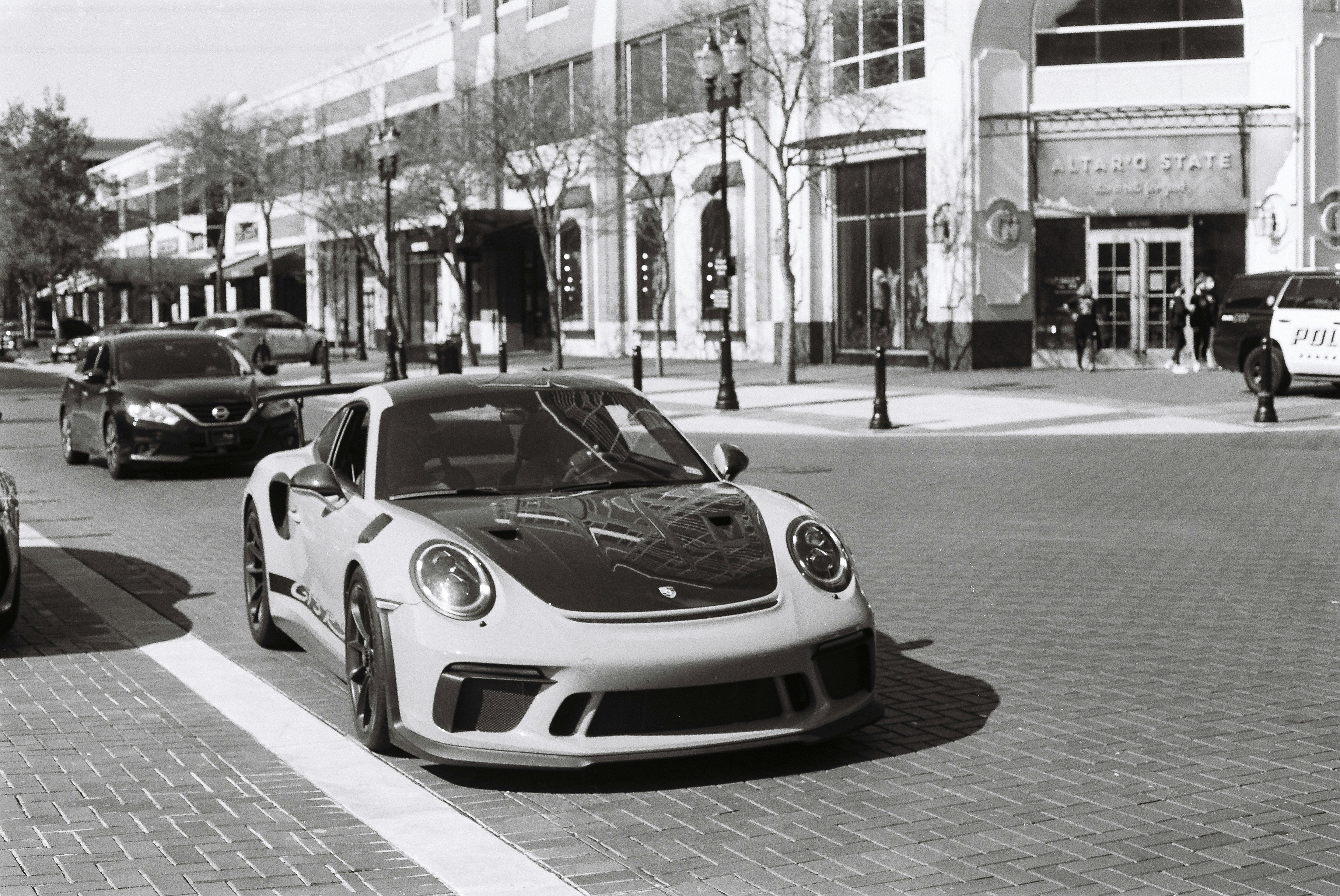 grayscale photo of bmw m 3 coupe parked on sidewalk