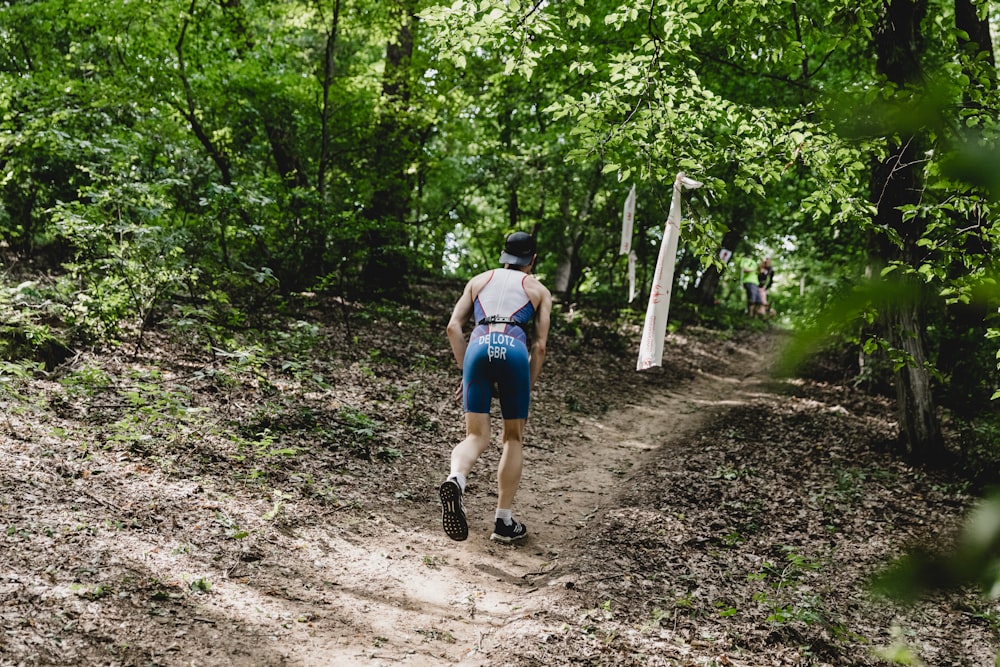 Un hombre caminando por un camino de tierra en el bosque