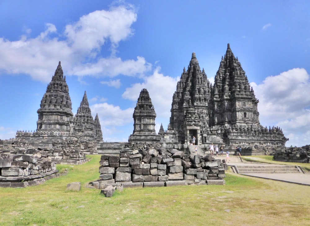 a large group of stone structures sitting on top of a lush green field