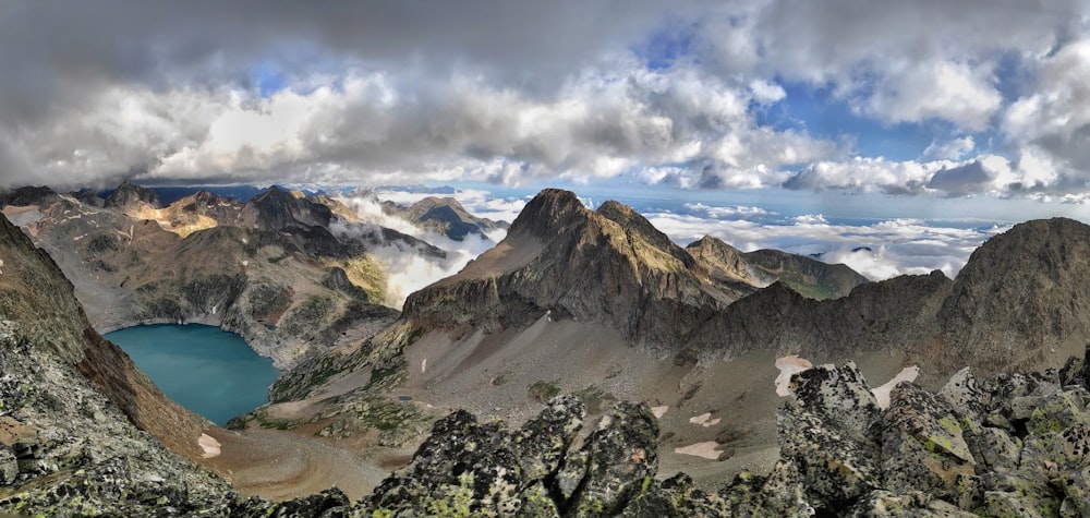 green trees near brown mountain under white clouds during daytime