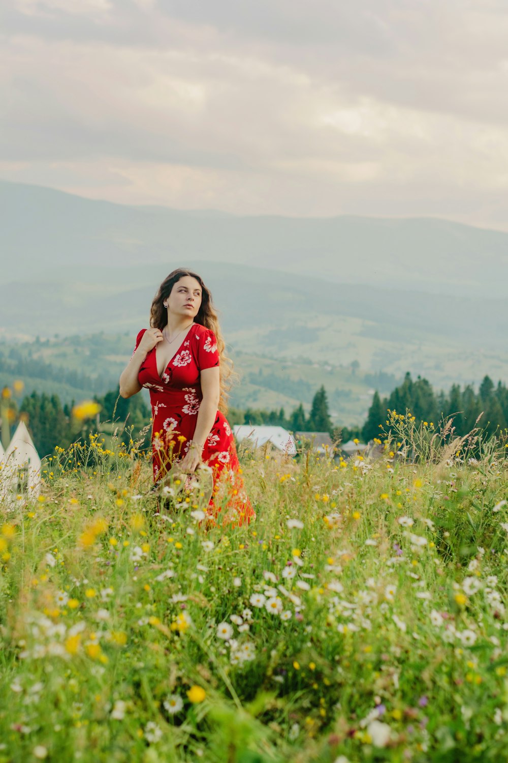 woman in red and white floral dress standing on flower field during daytime