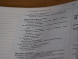 A close-up view of a page from a book, specifically a Biblical text. The text is organized into numbered sections, listing the genealogy of people from the region of Edom. The text includes various names such as Lotan, Shobal, and Alvan. The headings and sections are printed in distinguishable fonts, emphasizing hierarchy in the content.