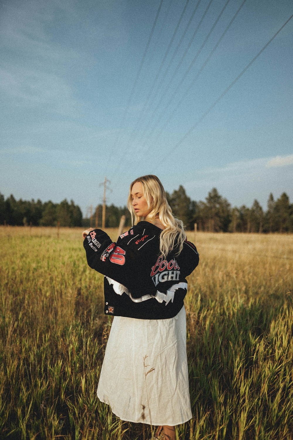 woman in black and red hoodie standing on green grass field during daytime