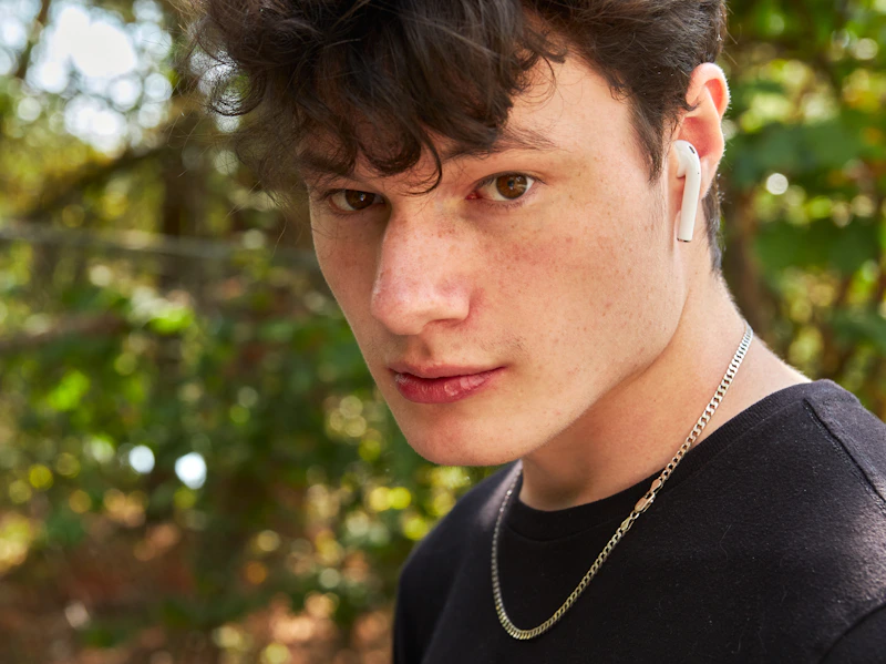 young man wearing earbuds outdoors