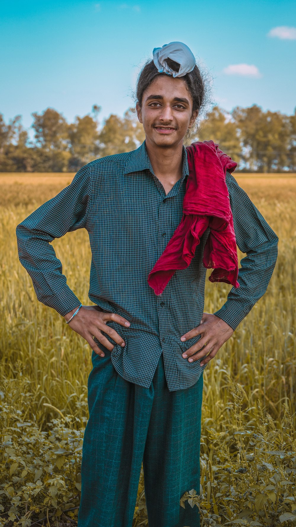 a man standing in a field with his hands on his hips