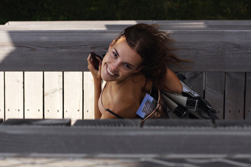 woman in black spaghetti strap top lying on gray wooden plank