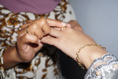 Close-up of hands exchanging gold jewelry as collateral for a gold loan.