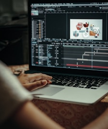 person using macbook pro on table