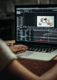 person using macbook pro on table