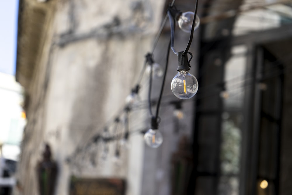 clear glass pendant lamp turned on during daytime