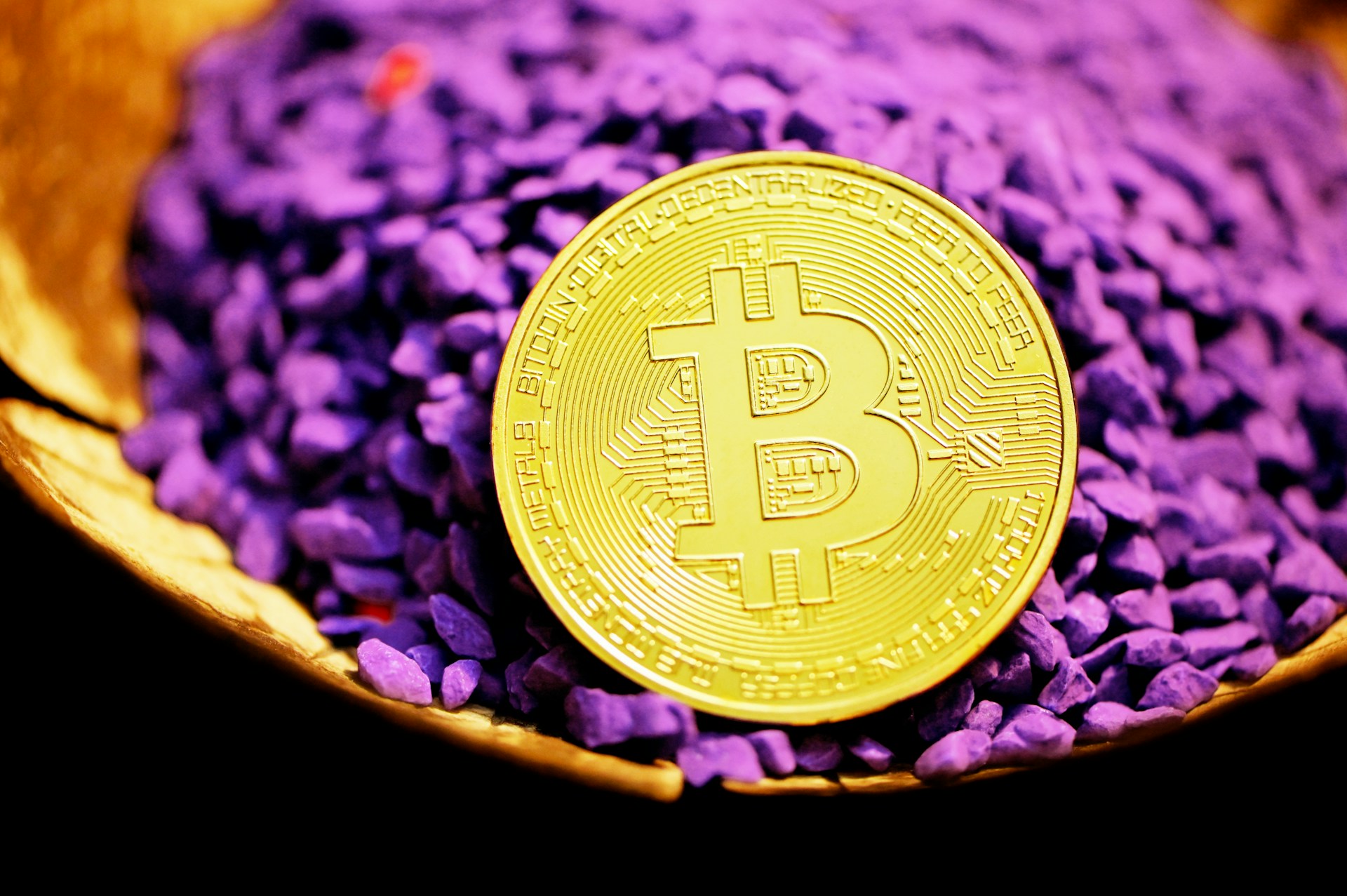 round gold coin on purple and black stones