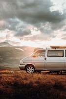 white suv on brown grass field near mountain during daytime