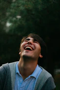 Vibrant portrait of a man laughing against a blurred urban background.