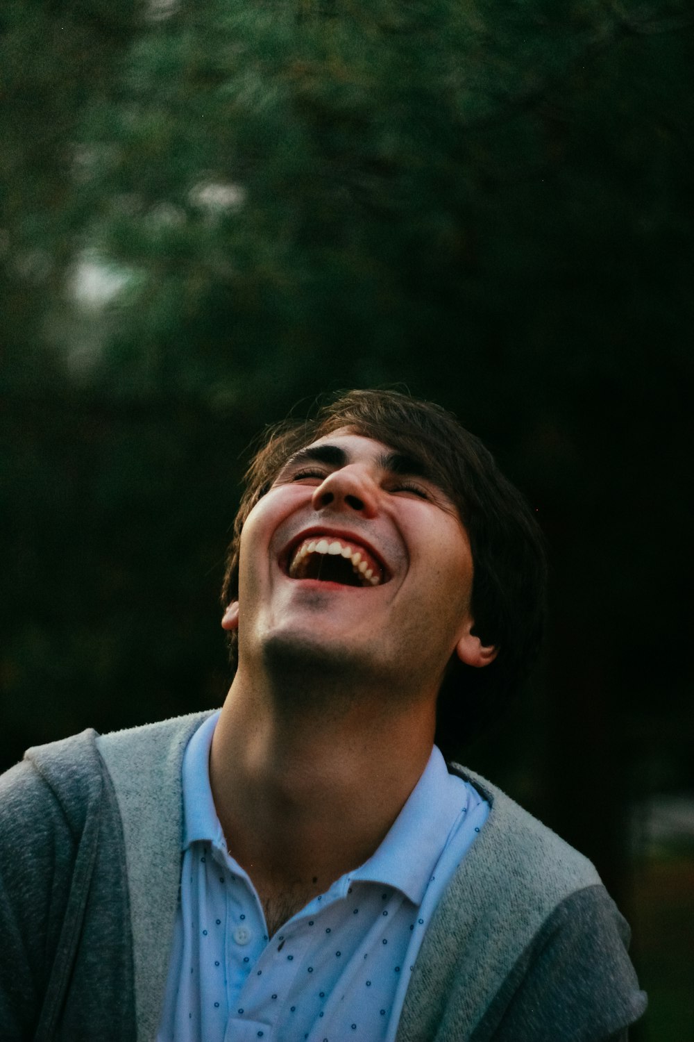 homem no suéter cinza sorrindo