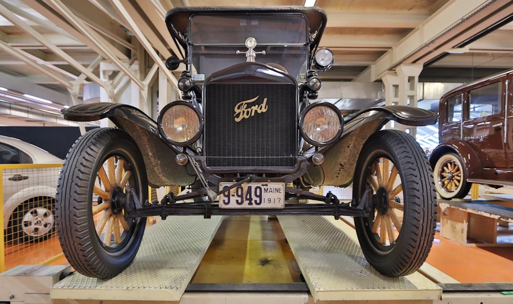 Voiture noire vintage garée sur un sol en béton gris