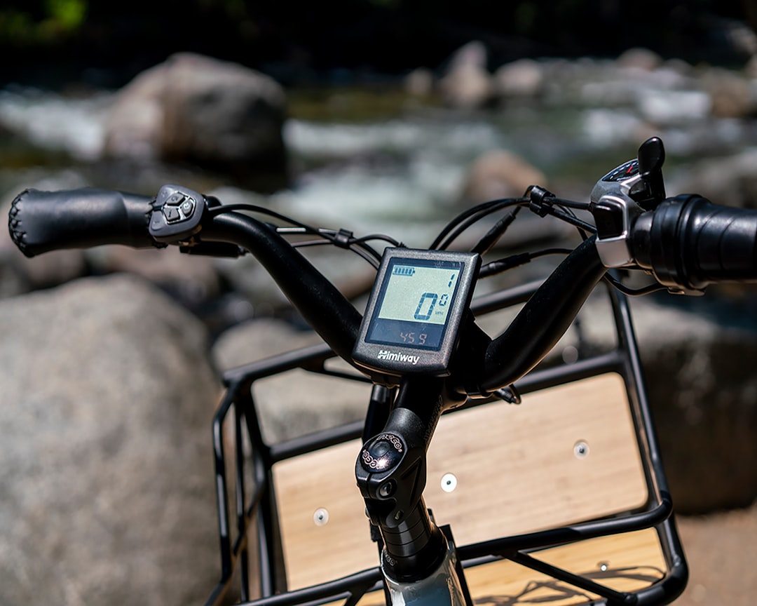 black bicycle handle bar near body of water during daytime