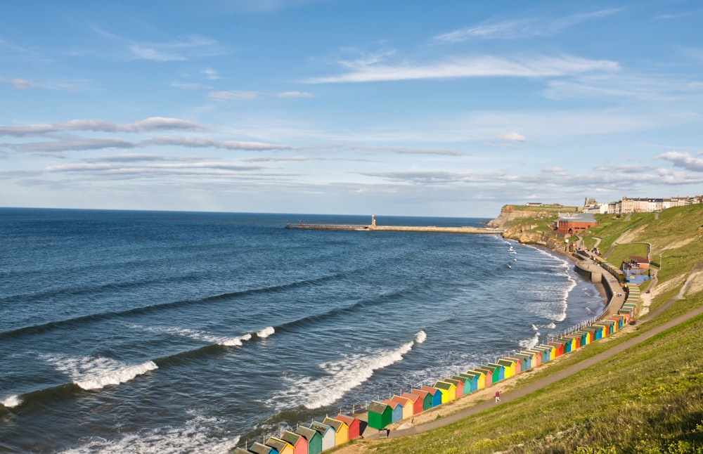 green and yellow houses near sea under blue sky during daytime