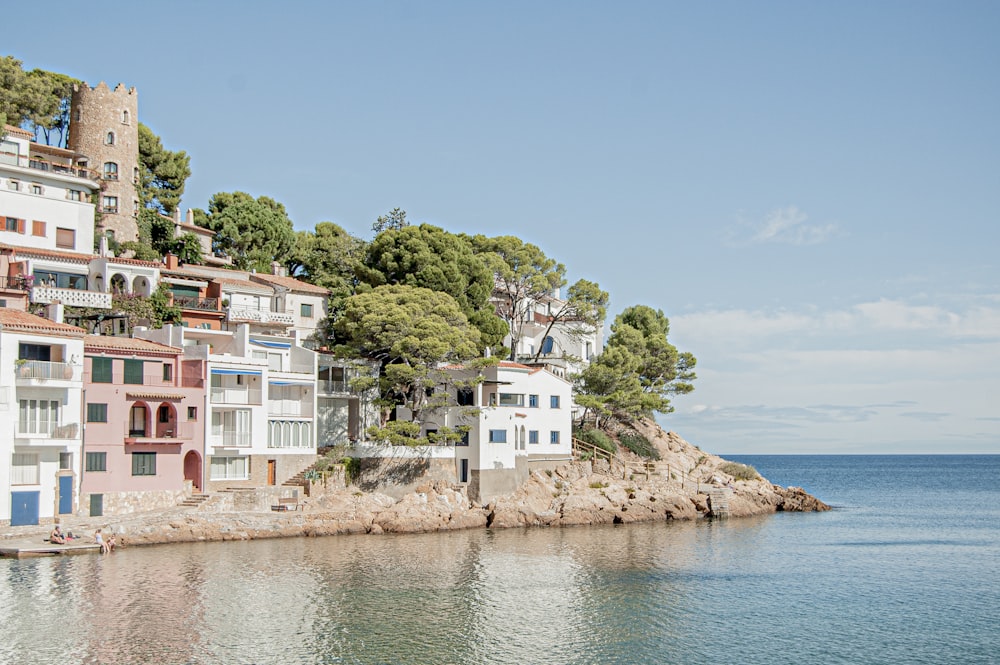 white and red concrete building beside body of water during daytime