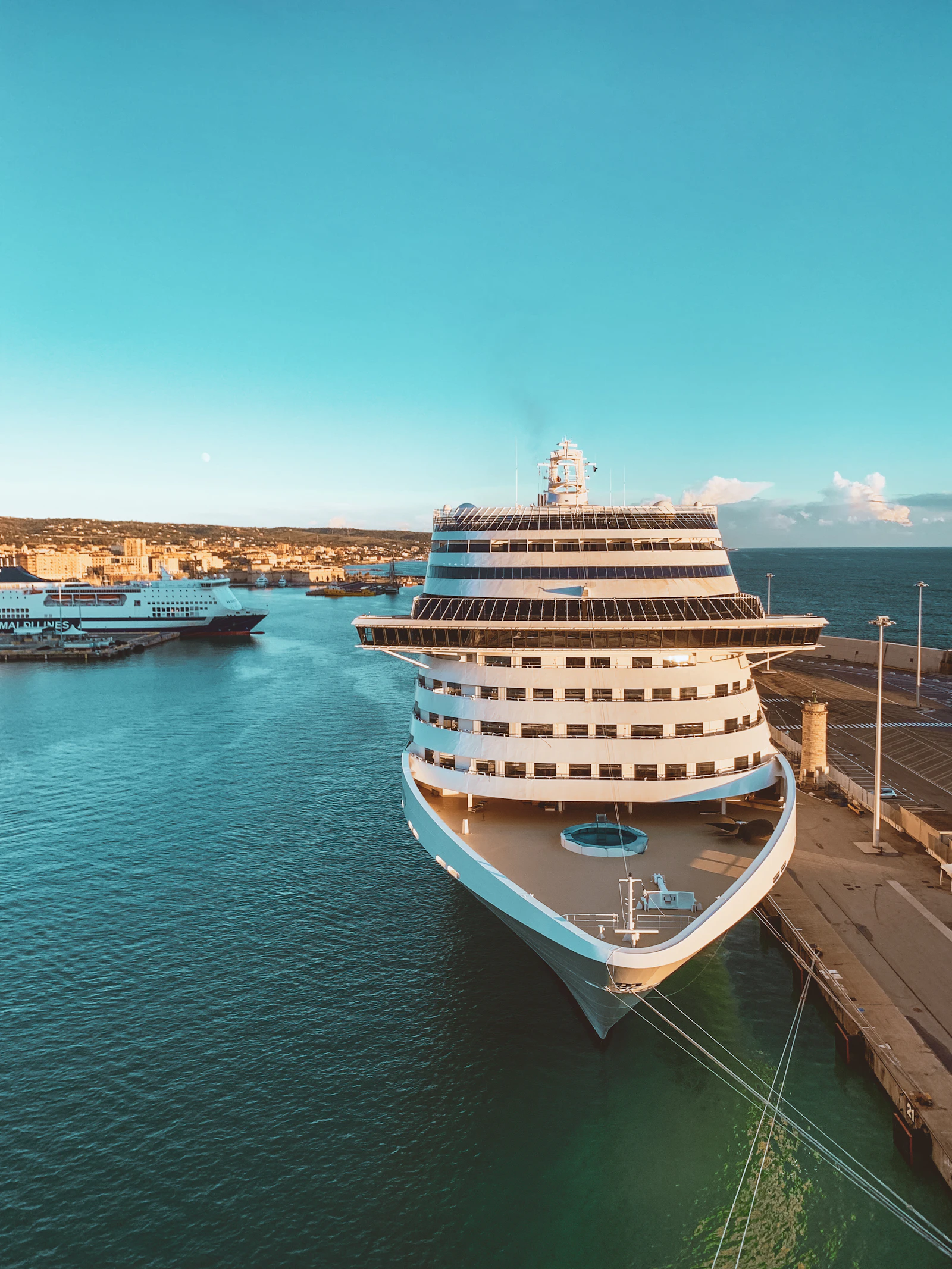 A white and blue cruise ship at sea under a clear sky