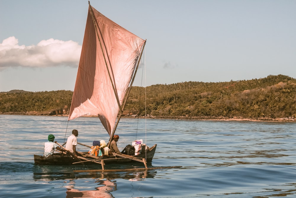 people riding on brown boat on sea during daytime