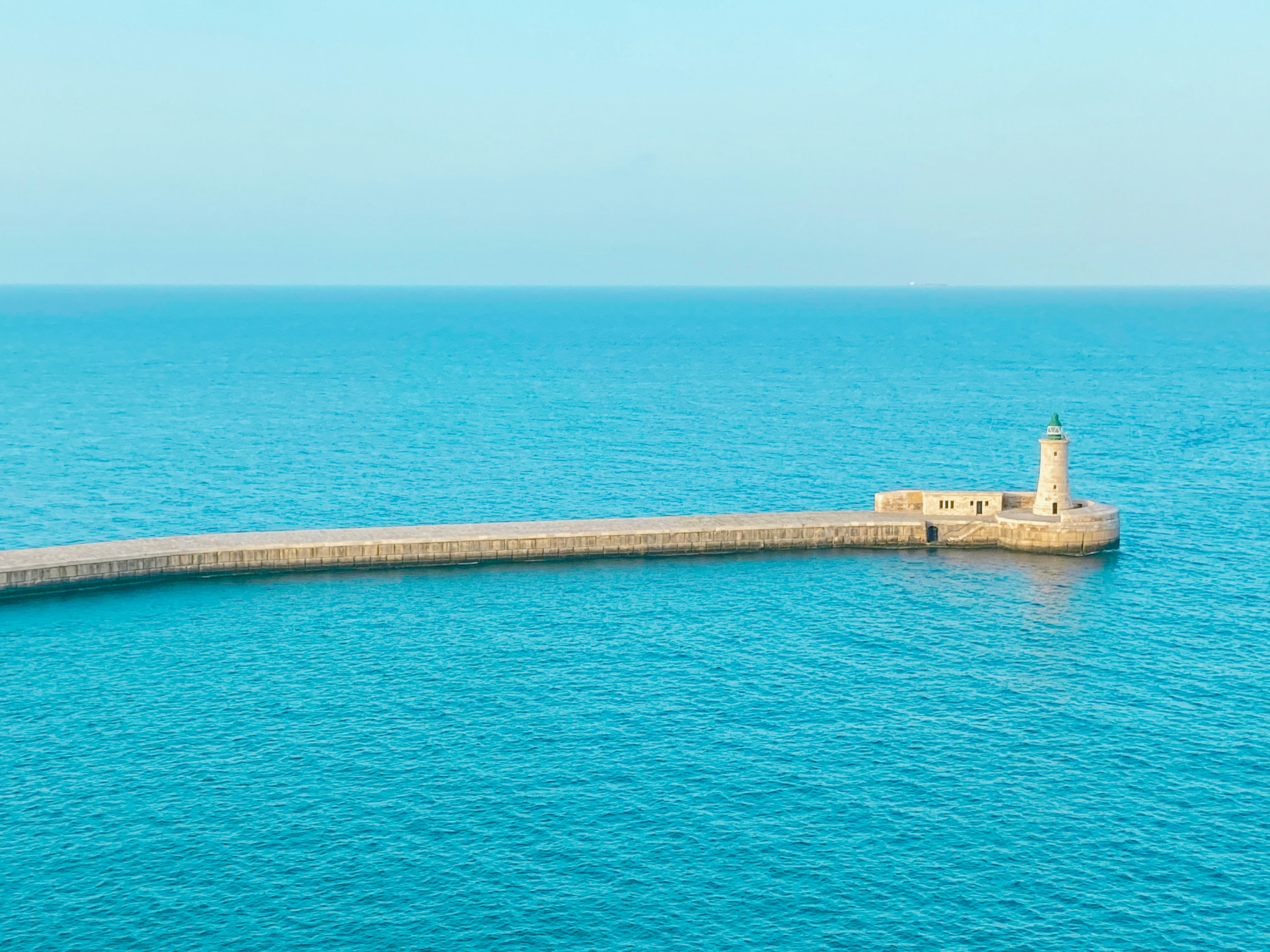 brown concrete dock on blue sea during daytime