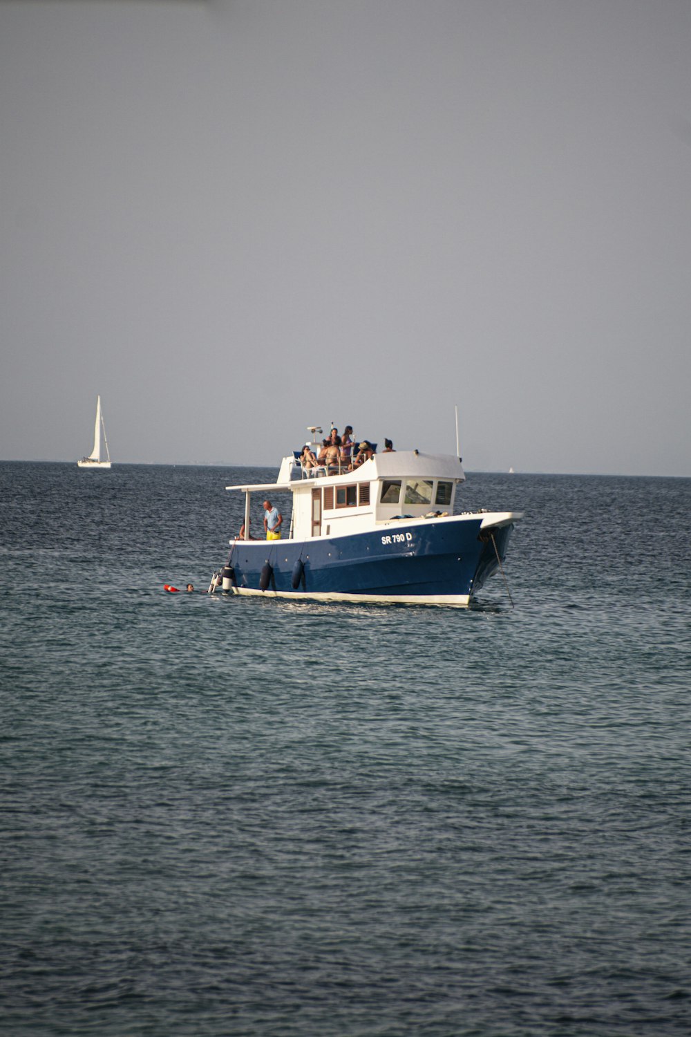 blue and white boat on sea during daytime