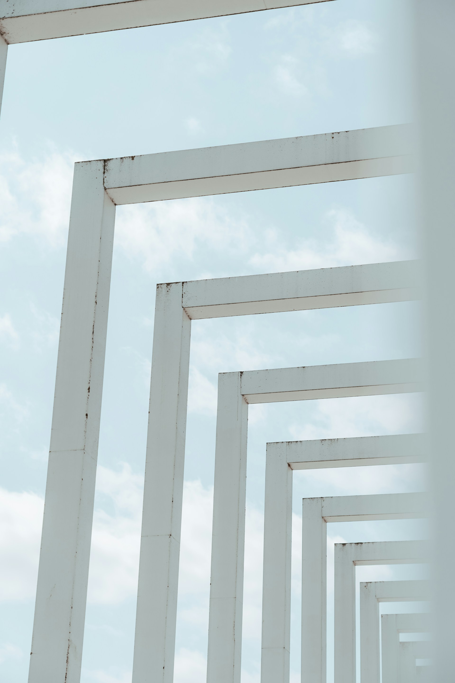 a row of white pillars against a blue sky