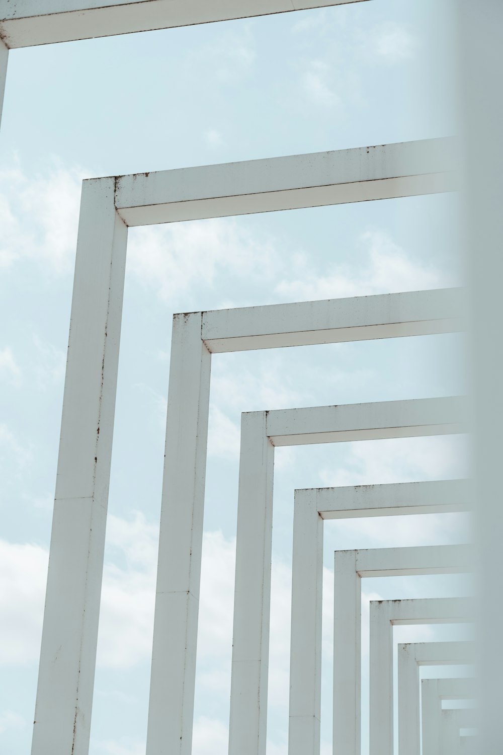 a row of white pillars against a blue sky