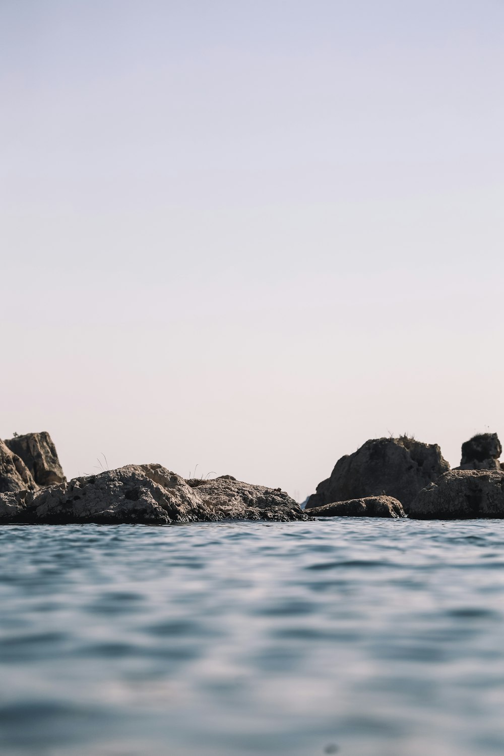 brown rock formation on blue sea under white sky during daytime